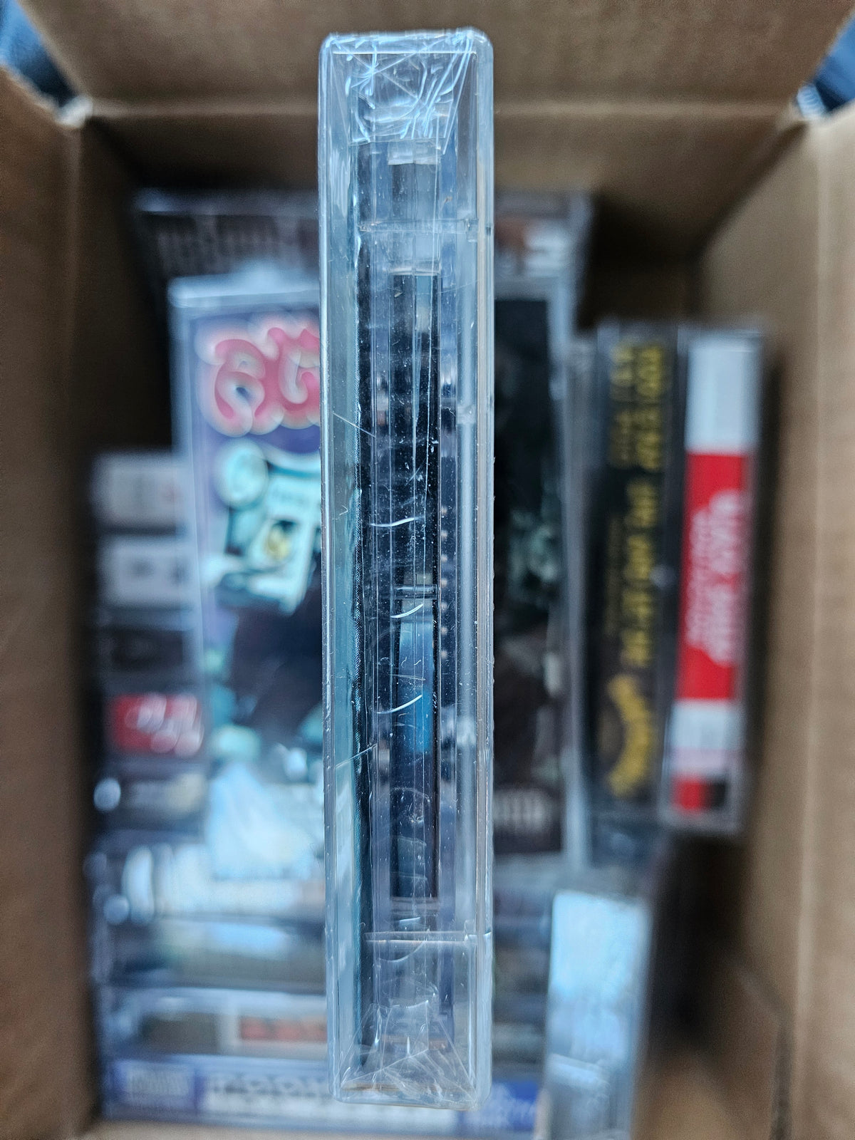 Individual cassette edge showing shrink-wrap folds and surface marks