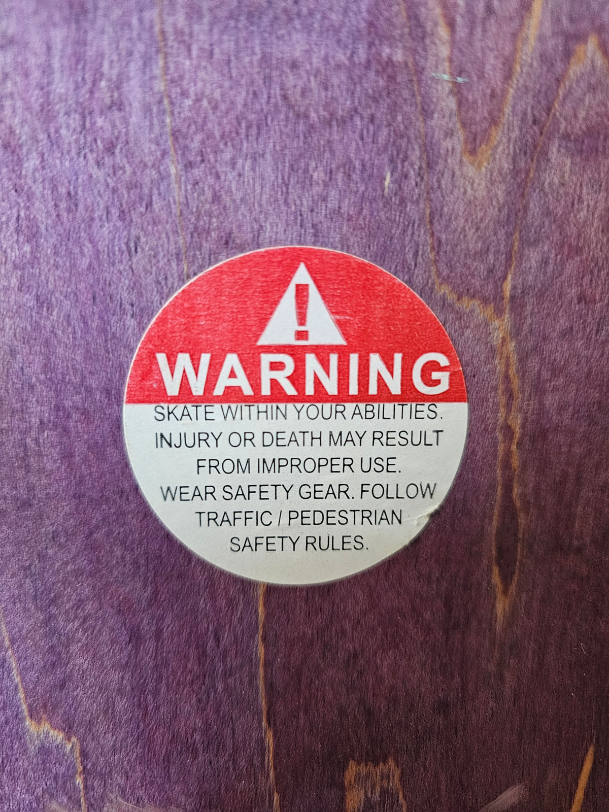 Close-up of warning sticker on purple woodgrain top