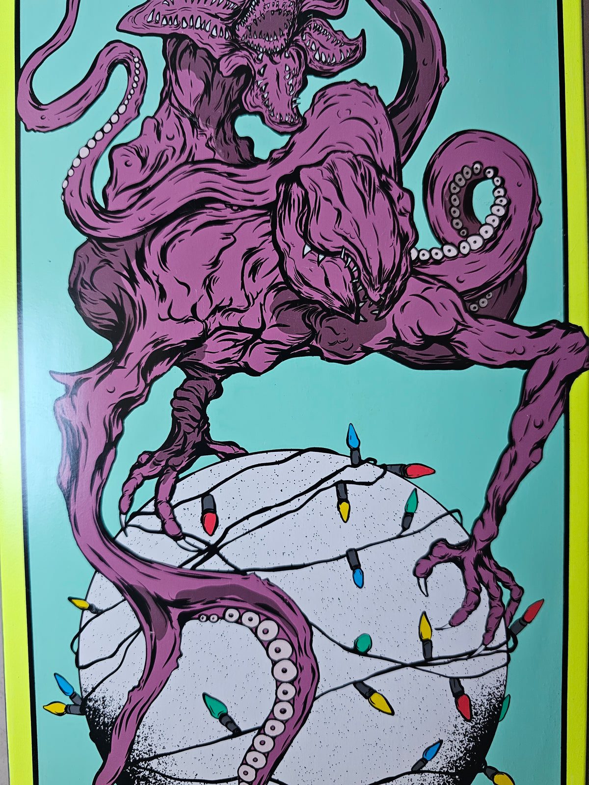 Close-up of purple creature illustration and multicolored string lights